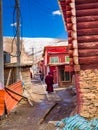 Tibetan buddhist monks walking in a nerrow street at Yarchen Gar