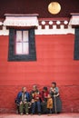 Tibetan Family sitting in front of the Langmusi Temple in Gansu, China