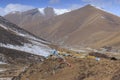 Tibetan landscape in China with prayer flags on foreground and mountains and yaks on background Royalty Free Stock Photo