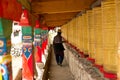 Tibetan man walking through corridor with prayer w