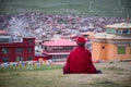 Tibetan monk sitting on the hill in Sichuan, China