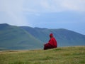 Tibetan monk sitting on the hill in Sichuan, China