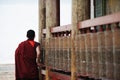 A tibetan monk turning prayer wheels