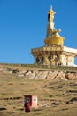 Tibetan monk walking into big Buddha in Yarchen Gar.