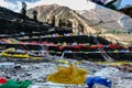 Tibetan prayer flags waving and swaddled with trees an mountain in sideway over frozen river with mountain in background. Royalty Free Stock Photo