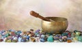 Tibetan Singing Bowl surrounded by tumbled healing stones Royalty Free Stock Photo