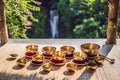 Tibetan singing bowls on a straw mat against a waterfall Royalty Free Stock Photo