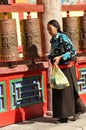 A Tibetan woman turning prayer wheels