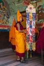 Tibetan young novice monk dress up and hold a banner , Nepal