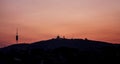 Tibidabo mountain silhouette, with the church and communications antenna of Collserola. Sunset in the city of Barcelona. Spain