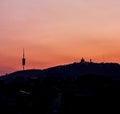 Tibidabo mountain silhouette, with the church and communications antenna of Collserola. Sunset in the city of Barcelona. Spain