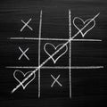 Tic tac toe game with chalk hearts, XO noughts and crosses Valentine`s Day style