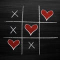 Tic tac toe game with chalk hearts, XO noughts and crosses Valentine`s Day style Royalty Free Stock Photo