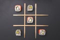 Tic tac toe game with sushi on dark black background, creative concept sushi rolls. Banner, playing tic tac toe game