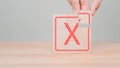 Tick and cross sign, approve and disapprove symbol. Hand placing wooden cube with red cross check mark sign.