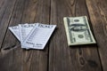 Tickets of the bookmaker office and money dollars lie on a wooden table, close-up