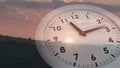 Ticking clock over sunset