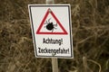 Ticks warning sign `Achtung! Zeckengefahr!` in Germany. Translation: Attention! Beware of Ticks! Royalty Free Stock Photo