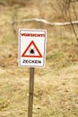 Ticks warning sign `Vorsicht Zecken` in Germany. Translation: Attention! Beware of Ticks! Royalty Free Stock Photo
