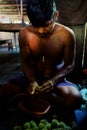 Ticuna indian tribal member pealing plant seeds to produce tribal paint for decoration