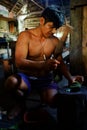 Ticuna indian tribal member squeezing plant seeds to produce tribal paint for decoration