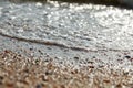 Tidal bore. The wave rolls onto the seashore, which is covered with shells. Coastline. Sea waves with white foam and shells beach Royalty Free Stock Photo