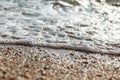 Tidal bore. The wave rolls onto the seashore, which is covered with shells. Coastline. Sea waves with white foam and shells beach Royalty Free Stock Photo