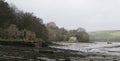 Tidal estuary at low tide: boats moored at anchor; mud; ruined lime kiln buildings