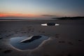 Tidal pools on beach with sunrise sunset and animal paw prints