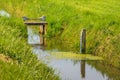 Tide gauge and small weir in a ditch Royalty Free Stock Photo