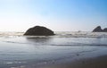 Tide lapping at the shore with huge rocks jutting out of the ocean Royalty Free Stock Photo