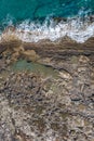 Tide pools during low tide on a rocky sea shore with dramatic texture, vertical top view Royalty Free Stock Photo