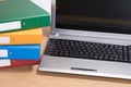 Tidy office desk with laptop and stacked folders