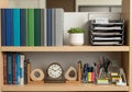 A tidy office shelf features an array of items. The top section holds a series of binders Royalty Free Stock Photo