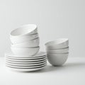 A tidy stack of white ceramic dishes and bowls arranged on a white surface. The Royalty Free Stock Photo
