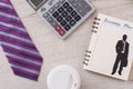 Tie, calculator and coffee mug in focus. Royalty Free Stock Photo