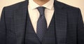 Tie goes inside vest. Vested three-piece suit worn with tie. Necktie collection. Fashion accessory. Formal style