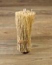 Tied bundle of straw on rustic wood