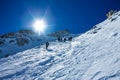 Tied climbers climbing mountain with snow field tied with a rope with ice axes and helmets