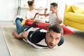 tied father with rocket toy lying on floor and children Royalty Free Stock Photo