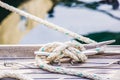 Tied knot with nautical rope on wood deck cleat of boat Royalty Free Stock Photo