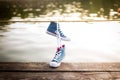 Tied pair of jeans sneakers hanging Royalty Free Stock Photo