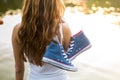 Tied pair of sneakers hanging on a girl Royalty Free Stock Photo