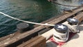 Tied rope knot on metallic bollard with stars, seafaring port of San Diego, California. Nautical ship moored in dock. Cable tie