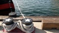 Tied rope knot on metallic bollard with stars, seafaring port of San Diego, California. Nautical ship moored in dock. Cable tie