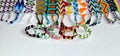 Tied woven friendship bracelets handmade of thread next to untied bracelets on white background