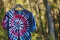 tiedye tshirt on wood hanger outdoors