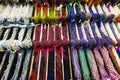 Tiered display of natural stone bead strands, grouped by type, each faceted bead reflecting colorful highlights