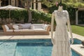 tiered summer dress on mannequin, near a poolside lounge Royalty Free Stock Photo