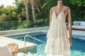 tiered summer dress on mannequin, near a poolside lounge Royalty Free Stock Photo